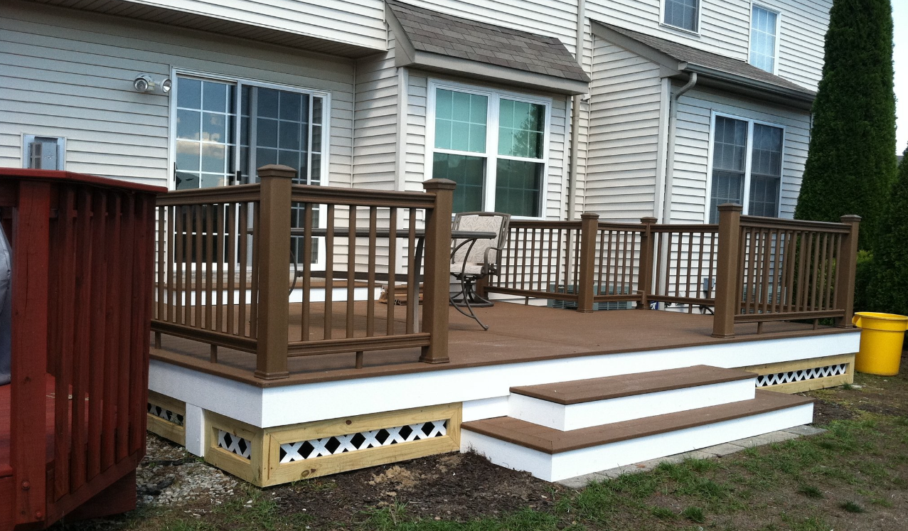 After - renovated deck with brown composite decking and white lattice